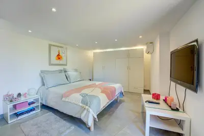 a bedroom with a bed and a flat screen tv at MAGNIFIQUE VILLA 8 PERSONNES in Vallauris