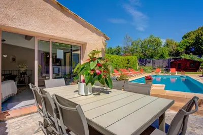a patio with a table and chairs and a pool at MAGNIFIQUE VILLA 8 PERSONNES in Vallauris
