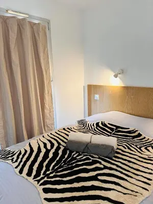 a living room with a couch and a balcony at à 10 min de la Croisette - pieds dans la mer in Cannes