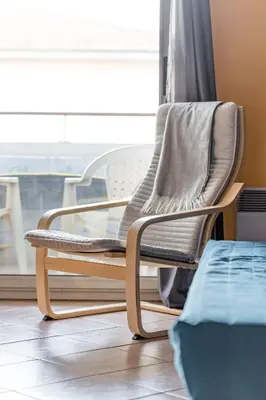 a rocking chair sitting in front of a window at la petit maisonette de manu in Cannes