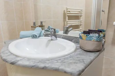 a bathroom counter with a white sink and a mirror at la petit maisonette de manu in Cannes