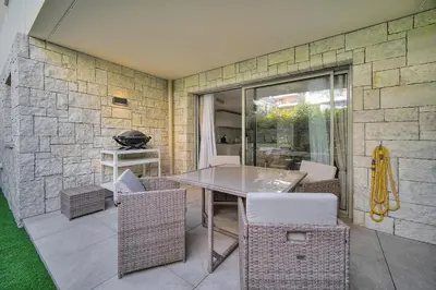 a patio with a table and chairs and a stone wall at IMMOGROOM - Garden - Bikes - BBQ - Parking - AC in Cannes
