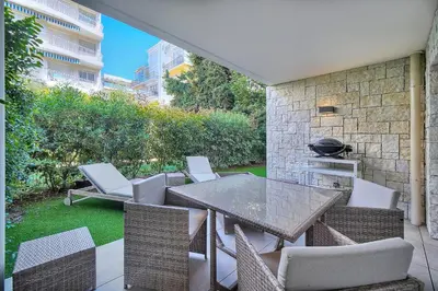 a patio with a table and chairs and a grill at IMMOGROOM - Garden - Bikes - BBQ - Parking - AC in Cannes