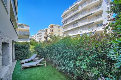 two chairs on a lawn in front of a building at IMMOGROOM - Garden - Bikes - BBQ - Parking - AC in Cannes