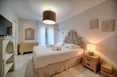a bedroom with a bed and a lamp and a mirror at IMMOGROOM - Garden - Bikes - BBQ - Parking - AC in Cannes