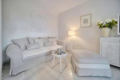 a white living room with a couch and a table at IMMOGROOM - Garden - Bikes - BBQ - Parking - AC in Cannes