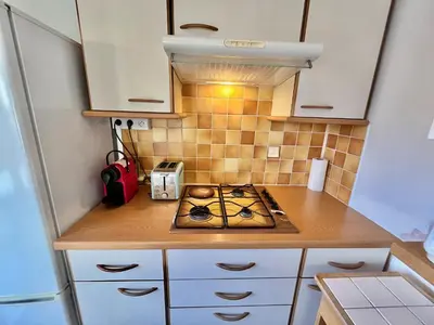 a small kitchen with a stove in the middle at Kent studio by Welcome to Cannes in Cannes