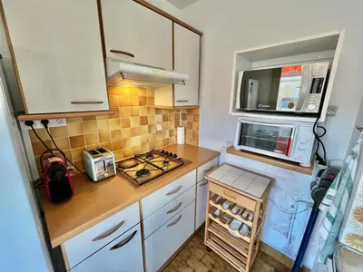 a small kitchen with white cabinets and a microwave at Kent studio by Welcome to Cannes in Cannes