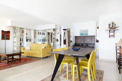 a dining room with a table and yellow chairs at On la Croisette XXL 1 bedroom with amazing sea view in Cannes