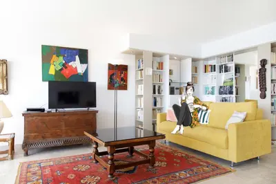 a living room with a yellow couch and a tv at On la Croisette XXL 1 bedroom with amazing sea view in Cannes