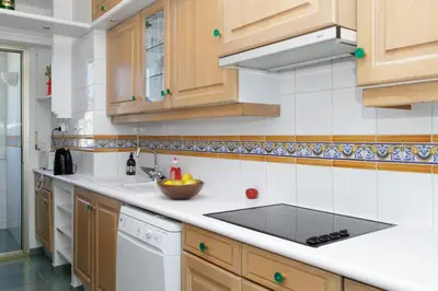 a kitchen with wooden cabinets and a sink at On la Croisette XXL 1 bedroom with amazing sea view in Cannes