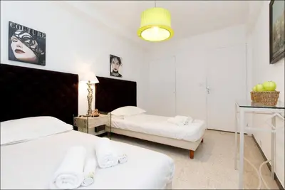 a bedroom with two beds and a table with a lamp at LUXURY APARTMENT between ANTIBS and CROISETTE in Cannes