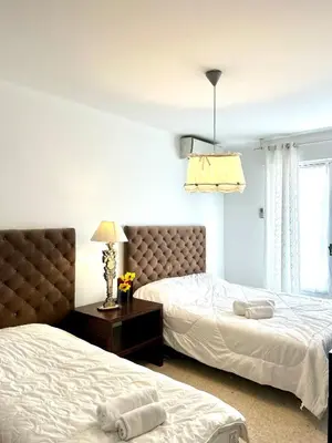 a bedroom with two beds and a chandelier at LUXURY APARTMENT between ANTIBS and CROISETTE in Cannes