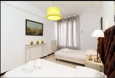 a white bedroom with two beds and a lamp at LUXURY APARTMENT between ANTIBS and CROISETTE in Cannes