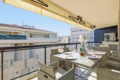a white bedroom with a large bed and a window at Carlton area XXL luxe 1 bed with large terrace in Cannes