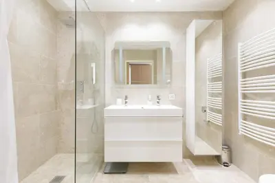a kitchen with white cabinets and a table with white chairs at Carlton area XXL luxe 1 bed with large terrace in Cannes