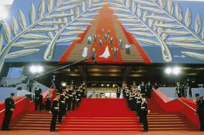 a group of people standing on a red carpet at Cannes beach and Festival Palais in Cannes
