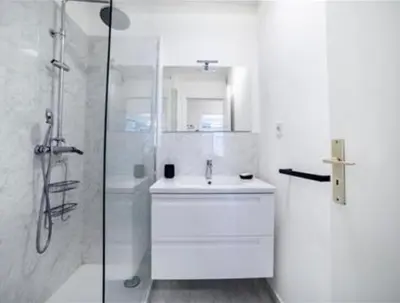 a white bathroom with a sink and a shower at Majestic in Cannes