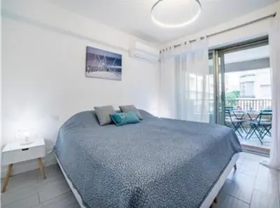 a bedroom with a large bed and a balcony at Majestic in Cannes