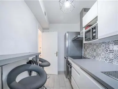 a kitchen with two black chairs sitting in a counter at Majestic in Cannes