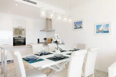 a white kitchen and dining room with a table and chairs at On La Croisette deluxe 2 bedrooms 2 baths in Cannes