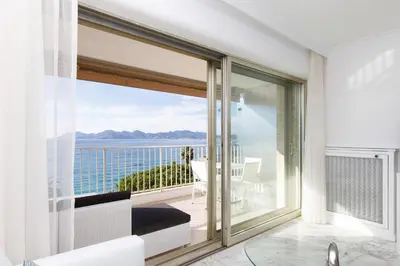 a room with a balcony with a view of the ocean at On La Croisette deluxe 2 bedrooms 2 baths in Cannes