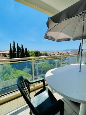 a white table and an umbrella on a balcony at Floriana in Cannes