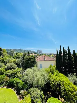 a house in a garden with trees and bushes at Floriana in Cannes