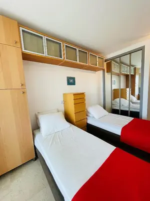 two beds in a small room with a mirror at Floriana in Cannes
