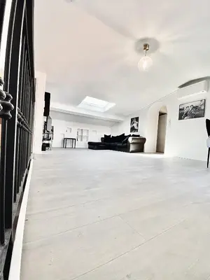 a living room with white walls and a wooden floor at Serbes Top Floor in Cannes