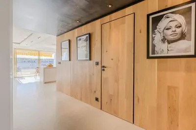 a hallway with wooden doors and a picture of a woman at 4-Room Apartment of 96m with a Stunning View in Cannes