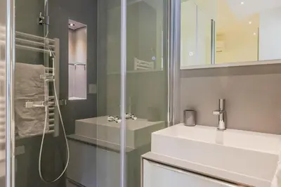 a bathroom with a white sink and a shower at 4-Room Apartment of 96m with a Stunning View in Cannes
