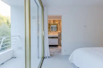 a white room with a bed and a mirror at 4-Room Apartment of 96m with a Stunning View in Cannes
