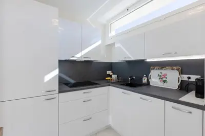 a white kitchen with white cabinets and a window at Luxurious 2-room Apartment in Palm Beach in Cannes