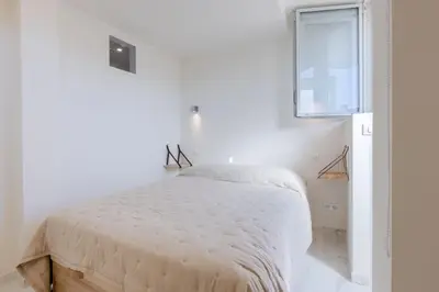 a white bedroom with a large bed with a window at Luxurious 2-room Apartment in Palm Beach in Cannes
