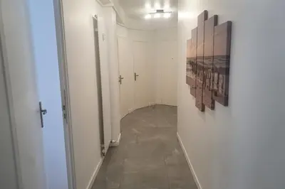 a hallway with white walls and a painting on a wall at Bel Apt Near Croisette Beach Cannes in Cannes