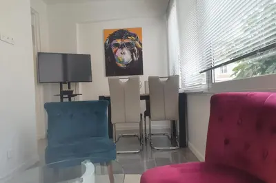 a living room with chairs and a painting of a dog at Bel Apt Near Croisette Beach Cannes in Cannes