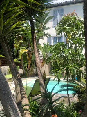 a pool with palm trees in front of a house at STUDETTE Beausejour in Cannes