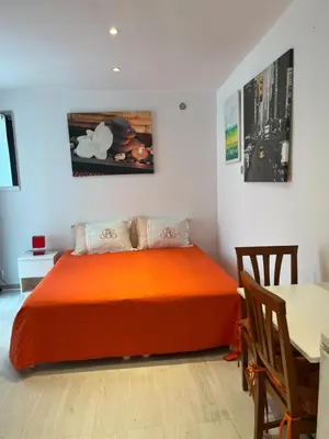 a bedroom with an orange bed and a table at STUDETTE Beausejour in Cannes