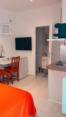 a living room with a kitchen and a table with a table at STUDETTE Beausejour in Cannes