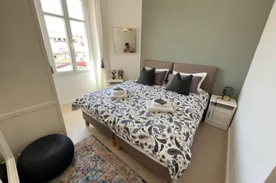 a bedroom with a bed with a black and white comforter at Nice 2 bedrooms Meynadier at 2 min BeachPalais in Cannes