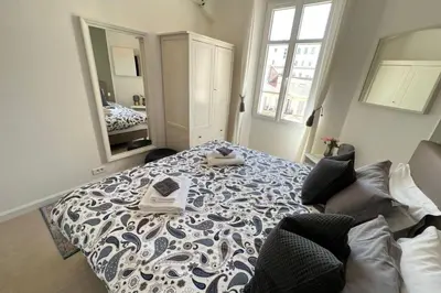 a bedroom with a blue and white bed with a mirror at Nice 2 bedrooms Meynadier at 2 min BeachPalais in Cannes