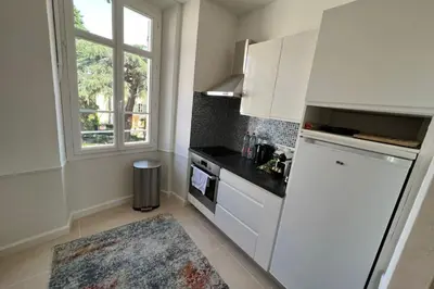 a kitchen with a white refrigerator and a window at Nice 2 bedrooms Meynadier at 2 min BeachPalais in Cannes