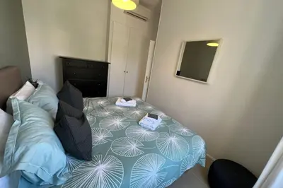 a small bedroom with a bed and a mirror at Nice 2 bedrooms Meynadier at 2 min BeachPalais in Cannes
