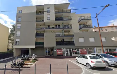a building with cars parked in a parking lot at Paul Doumer #2 By SCLS Locations in Le Cannet