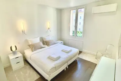 a white bedroom with a bed and a window at Arundel Croisette 100m Beach, Palais Free Parking AC Fibre in Cannes