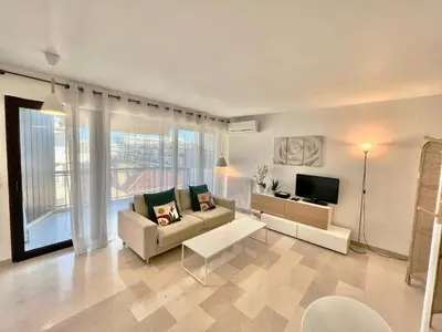 a living room with a couch and a tv at Les jardins de la Croisette 6, by Welcome to Cannes in Cannes