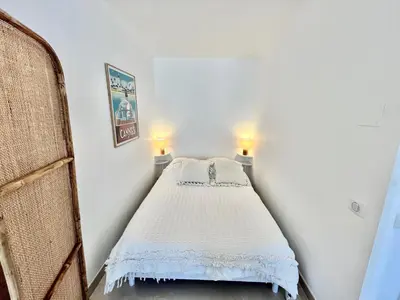 a bed in a room with two lights on the wall at Les jardins de la Croisette 6, by Welcome to Cannes in Cannes