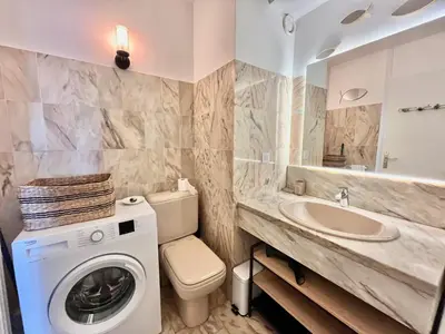 a bathroom with a washing machine and a sink at Les jardins de la Croisette 6, by Welcome to Cannes in Cannes