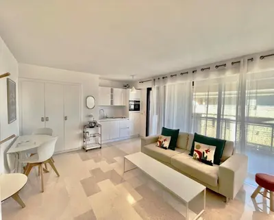 a living room with a couch and a table at Les jardins de la Croisette 6, by Welcome to Cannes in Cannes